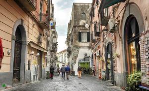 a group of people walking down a street between buildings at Casa Colombo in Vietri sul Mare