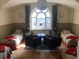 Cette chambre comprend deux lits, une table et des chaises. dans l'établissement Soldatens Bed & Breakfast, à Marstrand