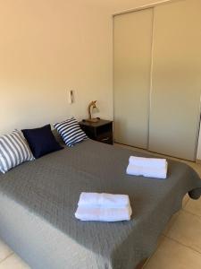 een slaapkamer met een bed met twee handdoeken erop bij Departamento Puerta del Rio in Villa María