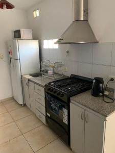 a kitchen with a stove and a refrigerator at Departamento Puerta del Rio in Villa María