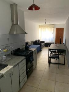 een keuken en een woonkamer met een fornuis en een tafel bij Departamento Puerta del Rio in Villa María