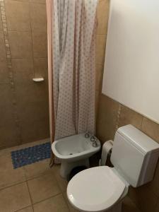 a bathroom with a toilet and a shower and a sink at Departamento Puerta del Rio in Villa María