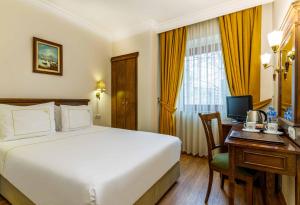 a hotel room with a bed and a desk with a computer at Golden Crown Hotel in Istanbul