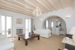 a living room with a white couch and a table at Andromeda Private Infinity Pool Villa in Fanari