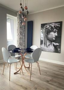jadalnia ze stołem, krzesłami i obrazem w obiekcie Apartament Złote Noce w mieście Augustów