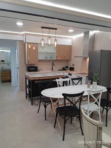 a kitchen with a table and some chairs and a counter at Apartamento Isaac junto a la muralla Romana in Lugo