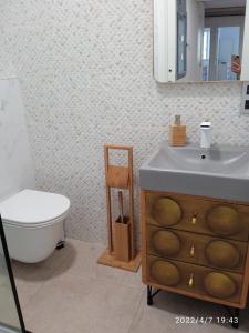 a bathroom with a sink and a toilet and a mirror at Apartamento Isaac junto a la muralla Romana in Lugo