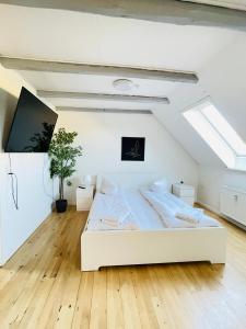 ein Schlafzimmer mit einem großen weißen Bett im Dachgeschoss in der Unterkunft aday - Reberbansgade Apartment Suite in Aalborg