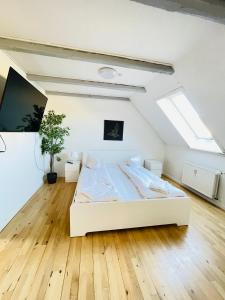 a large white bed in a room with wooden floors at aday - Reberbansgade Apartment Suite in Aalborg