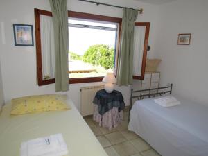 sypialnia z dwoma łóżkami i oknem w obiekcie Villa Helios w mieście Cala Pi