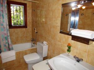 łazienka z toaletą, umywalką i lustrem w obiekcie Villa Helios w mieście Cala Pi +34 zdjęcia