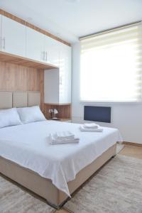 Un dormitorio con una cama grande con dos toallas encima. en Apartmani Martenovic, en Vrnjačka Banja