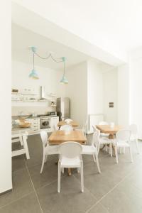 a dining room with tables and chairs and a kitchen at Tangram House in Pulsano