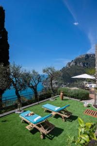 two picnic tables on the grass near the water at YourHome - Casa Ivi Positano in Positano