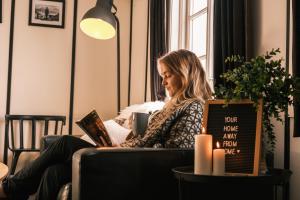 a woman sitting in a chair reading a book at Gjestehuset 102 - your home away from home! in Longyearbyen +95 photos