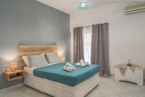 1 dormitorio con cama con sábanas azules y ventana en Sea View Villa, en Katastárion
