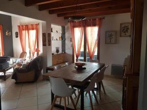 sala de estar con mesa de madera y sillas en Grande maison familiale, en Serres-Gaston