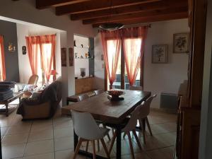 a living room with a wooden table and chairs at Grande maison familiale in Serres-Gaston