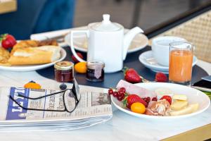 a table topped with plates of food and fruit at Hotel Indigo Cagnes-sur-Mer by IHG in Cagnes-sur-Mer