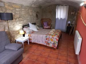 1 dormitorio con 1 cama y 1 sofá en una habitación en Cal Calçó en Pinós