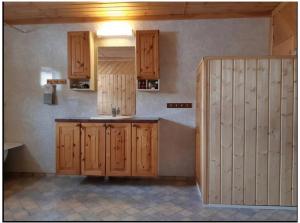 una cocina con armarios de madera y fregadero en Graceland Norway en Foldereid