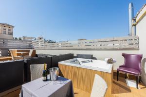 einen Balkon mit einem Tisch und einem lila Stuhl in der Unterkunft Hotel Castellino Roma in Rom