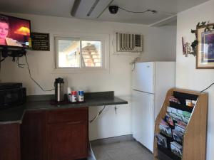 a kitchen with a white refrigerator and a window at Rapids Inn & Suites in Wisconsin Rapids