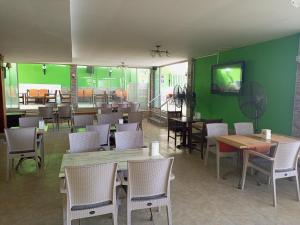 um restaurante com mesas e cadeiras e uma parede verde em Yuvam Prime Beach Hotel em Marmaris