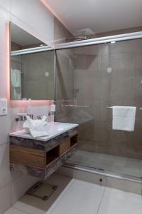 Polana Plaza Hotel في مابوتو: حمام مع دش زجاجي ومغسلة