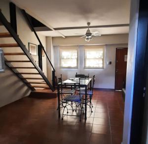 un comedor con mesa y sillas y una escalera en Duplex temporario Santa Fe en Santa Fe