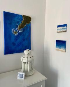 a table with a lantern and a painting on the wall at Casa Blu Cobalto in Maiori