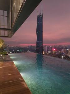 a swimming pool with a view of a city at night at Infinity pool/LUCENTIA BBCC,near TRX, KLCC, PNB118 in Kuala Lumpur