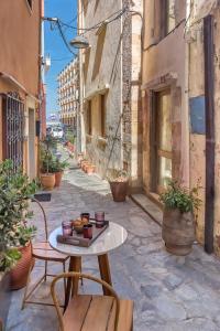 an alley with a table and chairs on a street at Casa Livieres in Chania