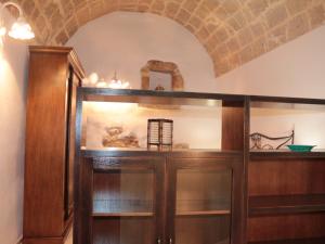 スペッキアにあるCasa vacanze Elisirの木製のキャビネット(ガラスの棚付)が備わる客室です。