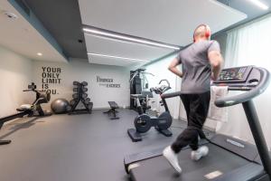 un homme sur un tapis de course dans une salle de sport dans l'établissement Hotel Indigo Cagnes-sur-Mer, an IHG Hotel, à Cagnes-sur-Mer