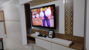 uma televisão de ecrã plano numa parede num quarto em Casa Térrea Oliveira inteira em São José dos Pinhais