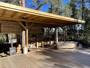 einem Holzpavillon mit einer Bank und einem Tisch in der Unterkunft Summer cabin in Nesodden open-air bath large terrace in Brevik