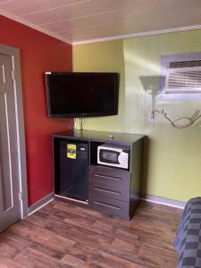 a living room with a flat screen tv on a wall at Budget Inn in Monroeville
