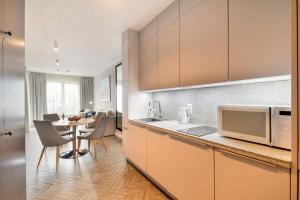 - une cuisine avec une table et un four micro-ondes dans l'établissement Klif Apartamenty Polanki Park, à Kołobrzeg