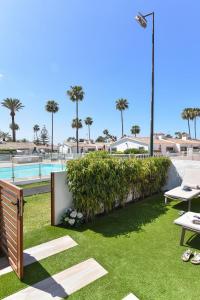 a resort yard with a hedge and a pool at Bungalow Santa Barbara EMC2 by VillaGranCanaria in Playa del Ingles