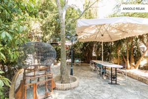 a patio with a table and an umbrella at Casavacanze Natura in Modica