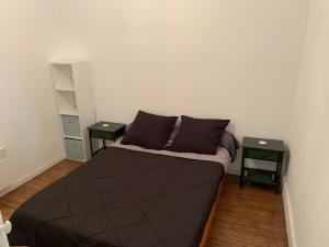 a small bedroom with a bed and two tables at Logement, idéal famille, amis, tout y est ! in Dompierre-sur-Besbre