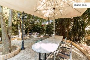 un tavolo con ombrellone su un patio di Casavacanze Natura a Modica