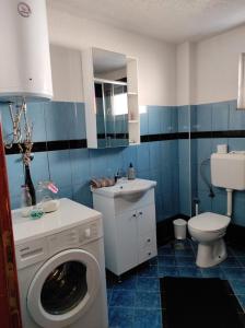 a bathroom with a washing machine and a sink at Apartman "Like at home" Jajce in Jajce