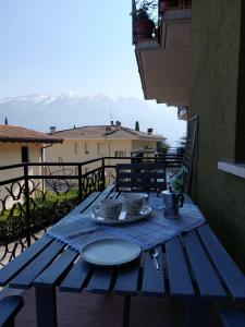 une table bleue avec une plaque sur le balcon dans l'établissement Casa Marica - Appartamento nel Borgo di Pieve, à Tremosine