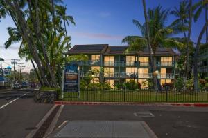 a building with palm trees in front of a street at GARDEN VIEW STUDIO - KONA ISLANDER INN CONDOS condo in Kailua-Kona