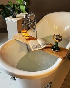 una bañera con un libro y dos velas. en Ancienne Perception, en Boussac