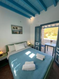 a bedroom with a blue bed with two towels on it at Patmos Villas in Grikos