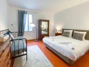 1 dormitorio con 1 cama grande y espejo en Entre Midi - Maison d'Hôtes - B&B, en Capestang