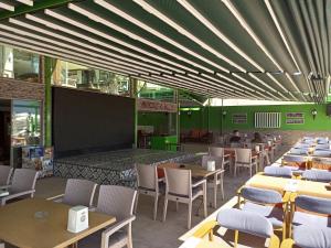 a restaurant with tables and chairs and a large screen at Yuvam Prime Beach Hotel in Marmaris